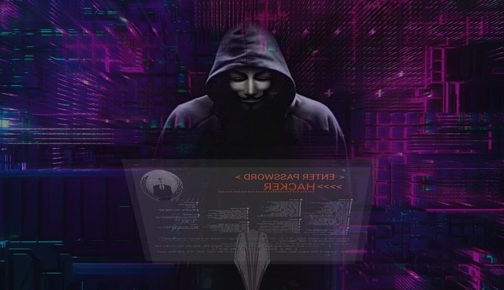 Hacker con maschera di anonymous che fa delle procedure di Red Teaming in forma di hacking