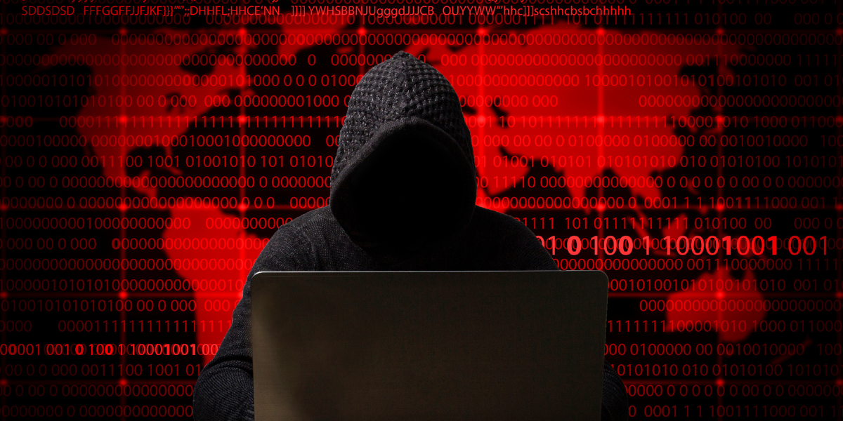 Hacker con felpa incappucciata seduto davanti a un laptop, con uno sfondo digitale rosso composto da codici binari e una mappa del mondo, simbolo di un cyberattacco globale. in stile Data Breach di InfoCert